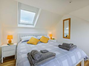 a bedroom with a bed with yellow pillows and a window at 5 Bed in Charmouth 83584 in Charmouth