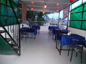a dining room with blue tables and chairs with a view at The Royal Lake View Villa in Udaipur