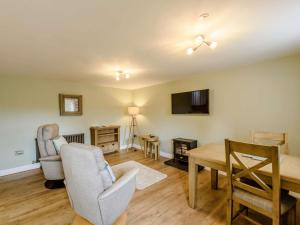 a living room with a table and chairs and a television at 1 Bed in Conwy 83950 in Llanrwst