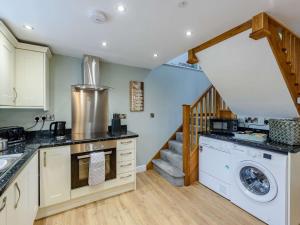 una cocina con lavadora y una escalera en 1 Bed in Conwy 83950 en Llanrwst