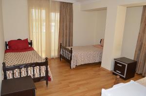 a bedroom with two beds and a wooden floor at Hotel Okriba in Kutaisi