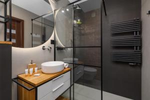 a bathroom with a sink and a shower at Near EXPO Cracow Elegant Apartment by Renters in Krakow