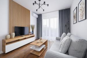 a living room with a couch and a tv at Near EXPO Cracow Elegant Apartment by Renters in Krakow