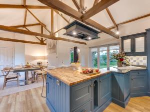 a kitchen with blue cabinets and wooden beams at 3 Bed in Richmond 86747 in Gilling