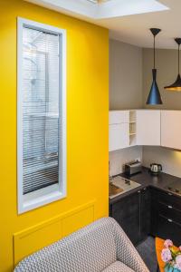 eine Küche mit gelber Wand und Fenster in der Unterkunft Appartement 11 place d'Alliance in Nancy