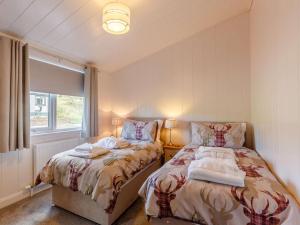 a bedroom with two beds next to a window at 2 Bed in Portree 87578 in Portree