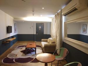 een woonkamer met een bank en een tafel en stoelen bij Katel Kuala Lumpur formally known as K Hotel in Kuala Lumpur