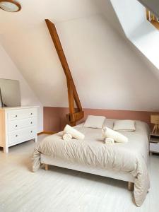 a bedroom with a white bed in a attic at La Boussole in Étretat