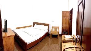 a bedroom with a bed and a desk and a tv at Nam Khánh Motel in Hanoi