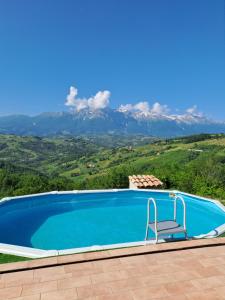 una piscina con sedia e montagne sullo sfondo di Casa Martin , 4 bedroom villa a Bisenti