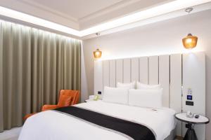 中レキ区にある168 Motel-Zhongliのベッドと椅子付きのホテルルーム