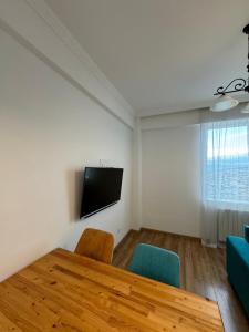 ein Esszimmer mit einem Tisch und einem Flachbild-TV in der Unterkunft Tea's apartment in Tbilisi in Tbilisi City