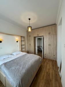 ein Schlafzimmer mit einem großen Bett und Holzböden in der Unterkunft Tea's apartment in Tbilisi in Tbilisi City