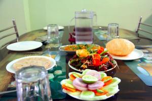 une table en bois avec des assiettes de nourriture dans l'établissement HOTEL KING SAFIRE , Port Blair, à Port Blair