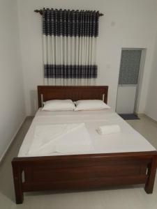 uma cama grande com uma estrutura de madeira num quarto em Mondial Dream Resort em Wellawaya