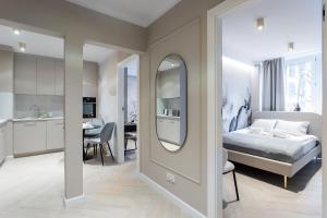 um quarto com uma cama, um espelho e uma cozinha em Grzybowska Rooms by Sofija em Varsóvia