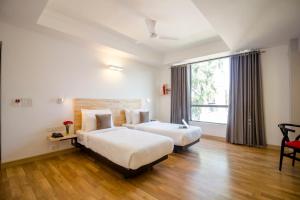 um quarto de hotel com duas camas e uma janela em Townhouse 013 New Friends Colony em Nova Deli