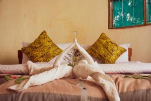 - un lit avec une serviette et des oreillers dans l'établissement Elephant View Lodge, à Kasenyi