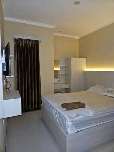 a bedroom with a large bed and a television at Omah Joglo Bugis in Wendit