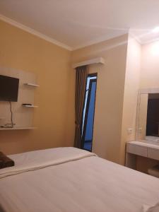 um quarto com uma cama, um espelho e uma janela em Omah Joglo Bugis em Wendit