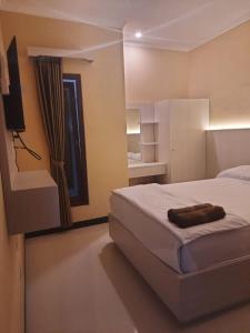 a bedroom with a bed and a television in it at Omah Joglo Bugis in Wendit