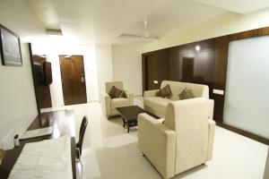 sala de estar con 2 sillas y mesa en Hotel green apple en Visakhapatnam