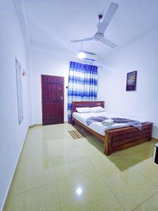 a bedroom with a bed and a ceiling fan at Chill Airport Transit Stay in Katunayake