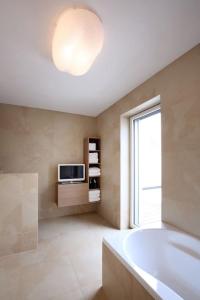 baño con bañera y TV en la pared en Elegantes Haus zum Wohlfühlen, en Viena