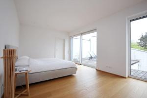 Dormitorio blanco con cama y ventana grande en Elegantes Haus zum Wohlfühlen, en Viena