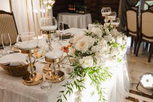 a table with white flowers and glasses on it at Na Pagorbi Lutsk in Lutsk