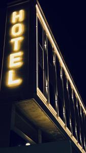 een verlicht bord aan de zijkant van een gebouw bij فندق قمم بارك Qimam Park Hotel 7 in Al Baha