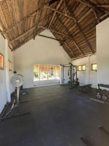 an empty room with a gym with weights and machines at Mango Beach Resort in Praia do Tofo
