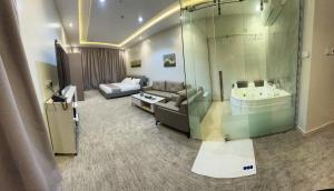uma ampla sala de estar com um sofá e uma banheira em قمم بارك الباحة Qimam Park Hotel 7 em Al Baha