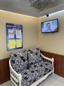 un sofá en una habitación con TV en la pared en Namar Hotel, en Ulán Bator
