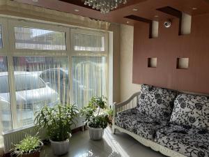 un salon avec un canapé et des plantes en pot dans l'établissement Namar Hotel, à Oulan-Bator