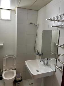 Baño blanco con lavabo y aseo en Namar Hotel, en Ulán Bator