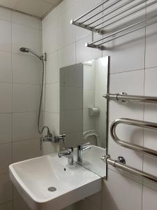 uma casa de banho branca com um lavatório e um espelho em Namar Hotel em Ulaanbaatar