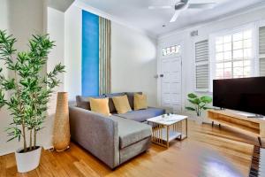 a living room with a couch and a tv at Gorgeous 2 Bedroom House Ultimo 2 E-Bikes Included in Sydney