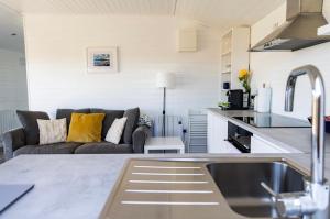 a kitchen and a living room with a couch at An Caban Ciuin in Doolin