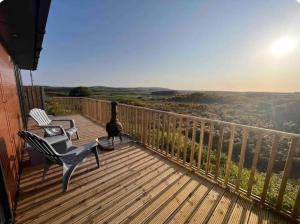 a balcony with two chairs and a view of the valley at doolinyoga luxury accommodation in Doolin