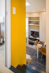 a yellow wall in a living room with a table at Appartement 11 place d'Alliance in Nancy