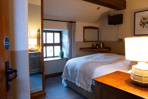 1 dormitorio con cama, ventana y espejo en Ye Olde Cheshire Cheese en Longnor