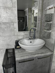 ein Badezimmer mit einem weißen Waschbecken und einem Spiegel in der Unterkunft Paradise in Tastybulak