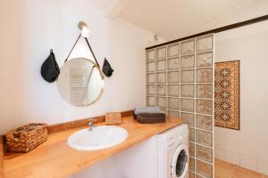 uma casa de banho com um lavatório e uma máquina de lavar roupa em Le Domaine de L'Osage em Pont-Saint-Esprit
