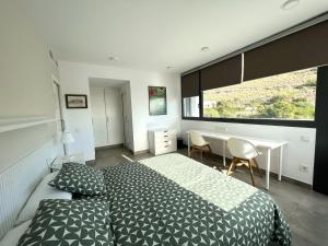 a bedroom with a bed and a desk and a window at Magnífica casa con encanto en Agua Amarga in Agua Amarga