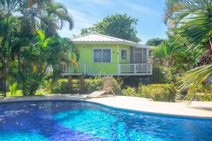 a house with a swimming pool in front of a house at Sand Dollar Bungalow in Roatan