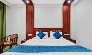 a bedroom with a large bed with blue pillows at FabHotel Majestic South Gate in Trivandrum