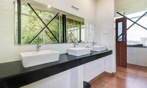 a bathroom with two sinks and a large window at FabHotel Majestic South Gate in Trivandrum