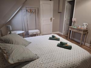 sypialnia z łóżkiem z dwoma zielonymi ręcznikami w obiekcie Les Gites de l'Herperie w mieście Blicourt