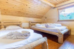 - une chambre avec 2 lits dans une cabane en bois dans l'établissement Resort 7 Crai - Cabana Baciu, à Zărneşti